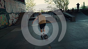 Young skater riding on skateboard at city skatepark. Boy jumping skate board.
