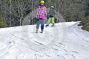 young skier begins to descend from a mid-level ski slope. Active recreation.