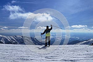 Young skier enjoys skiing. Preparing for start. Teenager waving others skiers. Panorama of Demanovska Valley in Slovakia Low