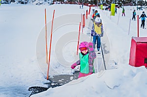 Young skier, girl going up on ski conveyor. Ski winter holidays in Andorra