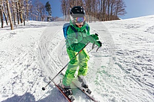 Young Skier skiing downhill during sunny day in high mountains