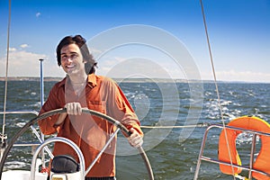 Young skipper driving sailboat