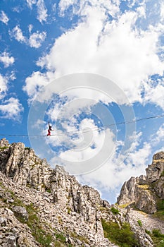 Young slackliner man balancing on a slackline betweend two rocks. Highline with a beautiful natural landscape behind