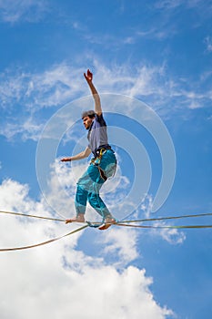 Young slackliner man balancing on a slackline betweend two rocks. Highline with a beautiful natural landscape behind