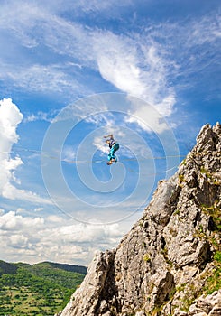 Young slackliner man balancing on a slackline betweend two rocks. Highline with a beautiful natural landscape behind