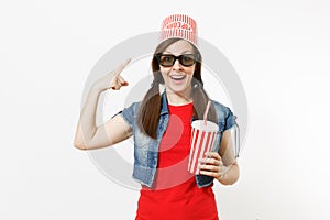 Young slaphappy woman in 3d glasses pointing index finger on bucket for popcorn on head watching movie film and holding
