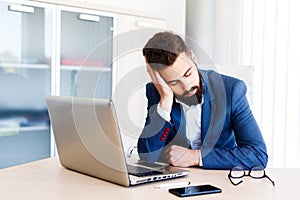 Young Sleepy Businessman Sitting At Workplace