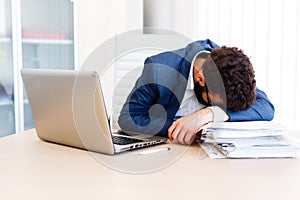 Young Sleepy Businessman Sitting At Workplace