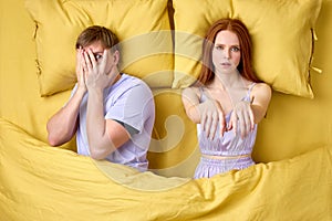 Male living with sleepwalker wife, lying on bed together, frightened photo