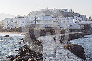 A young slender beautiful woman runs along the embankment along the sea