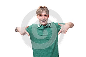 a young slender ginger man with a tattoo on his arm, dressed in a green T-shirt with bright facial expressions