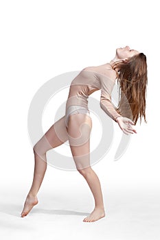 Young slender girl, with long hair, in a beige bodysuit, in the studio on a white background