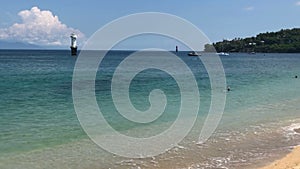 A young slender woman bathing in the blue sea in a tropical resort, Lombok Indonesia