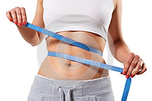 A young slender woman measures her waist with a centimeter tape. isolated on white background