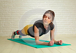 Young slim athletic woman doing fitness stretching exercises and pushups workout in studio healthy lifestyle