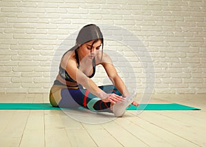 Young slim athletic woman doing fitness stretching exercises and pushups workout in studio healthy lifestyle