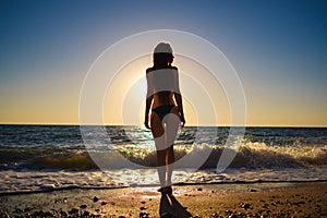 Young slim beautiful woman on sunset beach, playful, dancing, running, bohemian outfit, indie style, summer vacation, sunny,