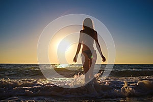 Young slim beautiful woman on sunset beach, playful, dancing, running, bohemian outfit, indie style, summer vacation, sunny,