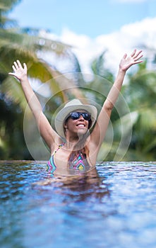 Young slim brunette woman sunbathe in tropical swimming pool