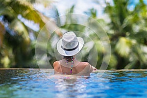 Young slim brunette woman sunbathe in tropical swimming pool