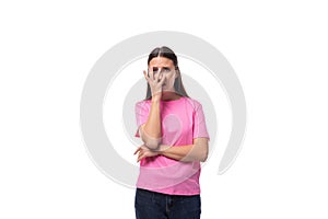 young slim caucasian brunette woman in a pink t-shirt on a white background with copy space