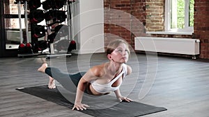 young slim caucasian woman standing in downward and upward facing dog pose asana