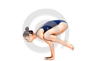 Young slim flexible woman doing arm balance yoga pose