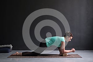 Young slim girl, doing horse rider exercise, anjaneyasana pose, working out.