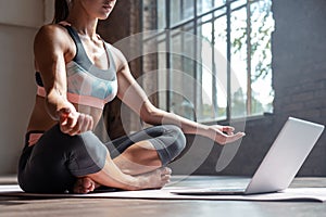 Young slim girl meditate online in hatha yoga easy pose healthy lifestyle.