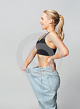 Young slim sporty woman in oversize pants