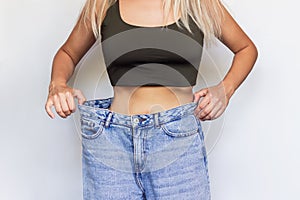 A  young slim woman demonstrates successful weight loss