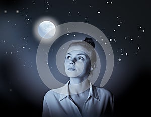 Young slim woman looking at full moon