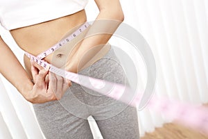 Young Slim Woman Measuring Waist With Tape Measure