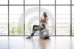 Young slim Woman in sportswear exercising her abs on a Pilates ball of fitball close up at gym. Fitness concept