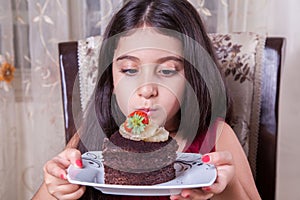 Young small beautiful middle eastern child girl with chocolate cake with pineapple, strawberry, and milk with red dress and dark