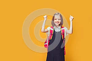 Young smart Caucasian student girl wearing backpack standing over isolated yellow background screaming proud and