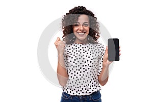 young smart caucasian woman with curly curled hair is happy to share the news holding smartphone screen forward