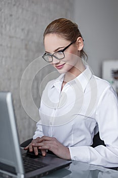 Young costumer support employee with laptop smiling on office photo