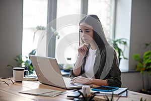 Young smart girl looking at laptop screen.