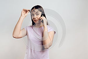 Young smart girl politely communicates on cell phone.