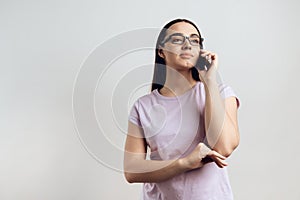 Young smart girl politely communicates on cell phone.