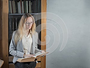 A young smart intelligent woman sits with a book in her hands