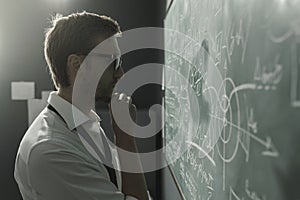 Young smart mathematician drawing on the chalkboard photo