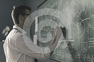 Young smart mathematician drawing on the chalkboard photo