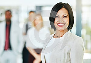 Young, smart and smiling businesswoman with a diverse team at work ready to achieve success. Confident female