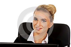 Young smile businesswoman behind the desk, using laptop