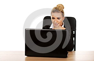 Young smile businesswoman behind the desk, using laptop