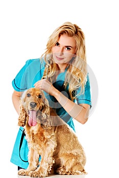 Young smile female veterinarian examinng dog