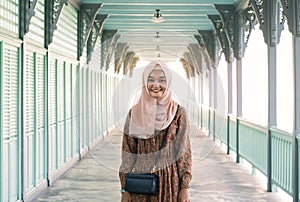 Young smiling Asian muslim girl standing outdoors looking at camera
