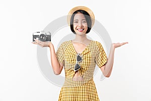 Young smiling Asian woman tourist holding camera and looking to copy space on white background.